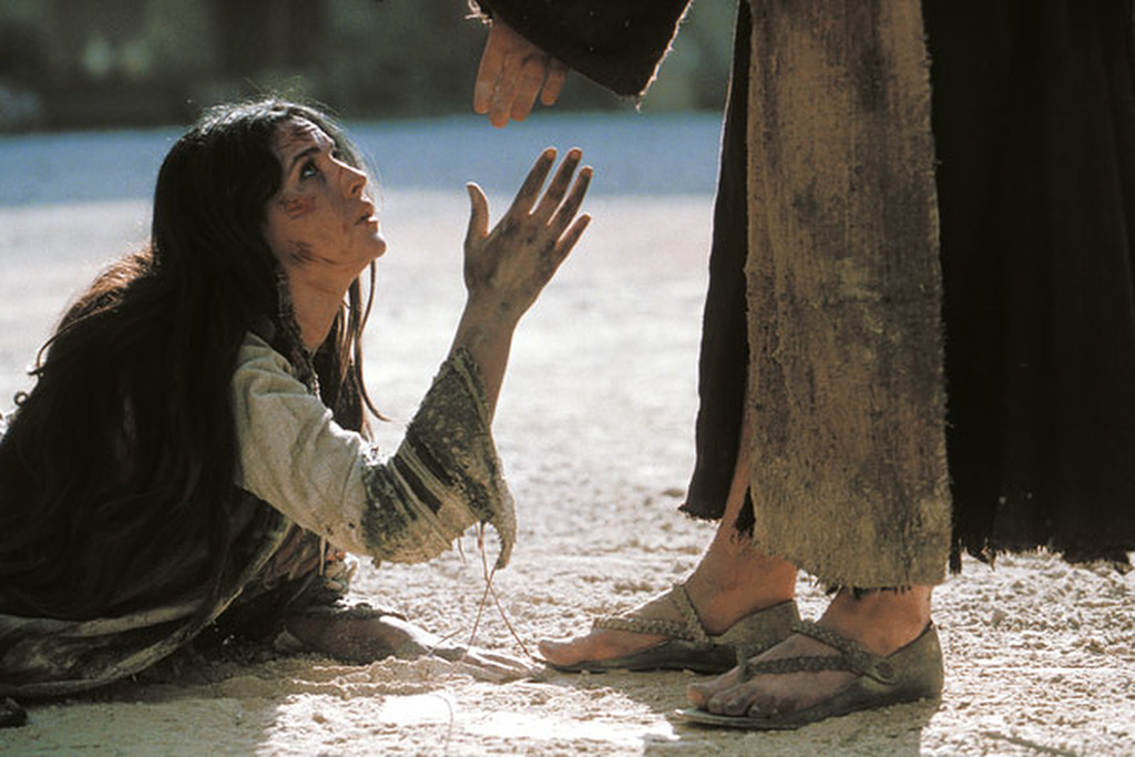 Mujer arrodillada a los pies de Jesús