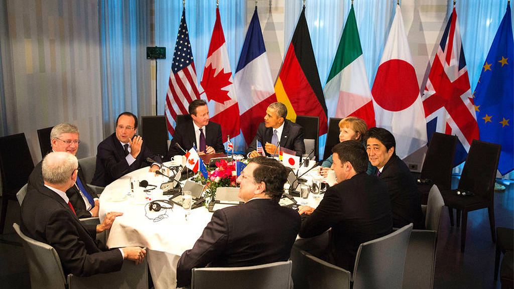Líderes de varias naciones reunidos alrededor de una mesa con sus banderas, entre ellas la de la Unión Europea